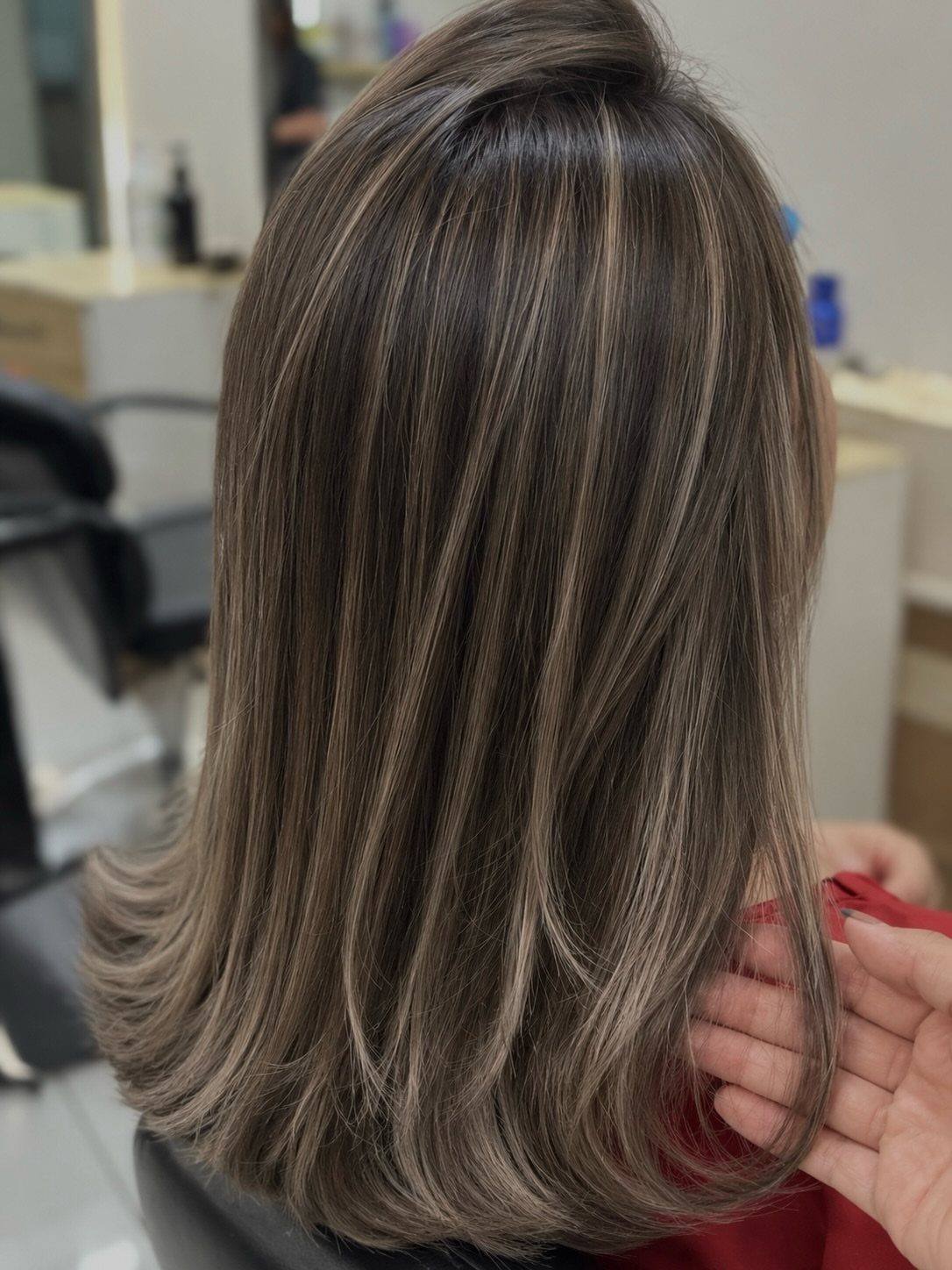 Cool ash bronde hair blends dark brunette strands with dimensional blonde highlights