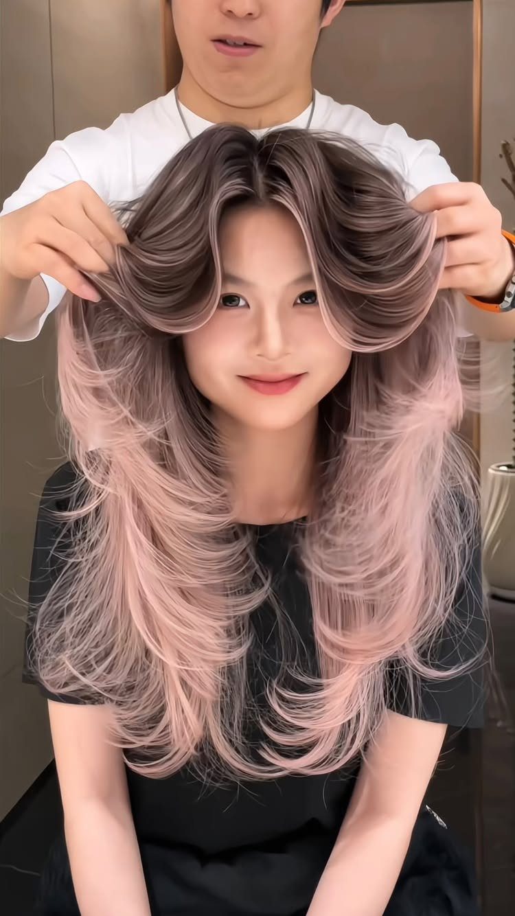 Woman showing long brown hair that fades into soft pastel pink waves
