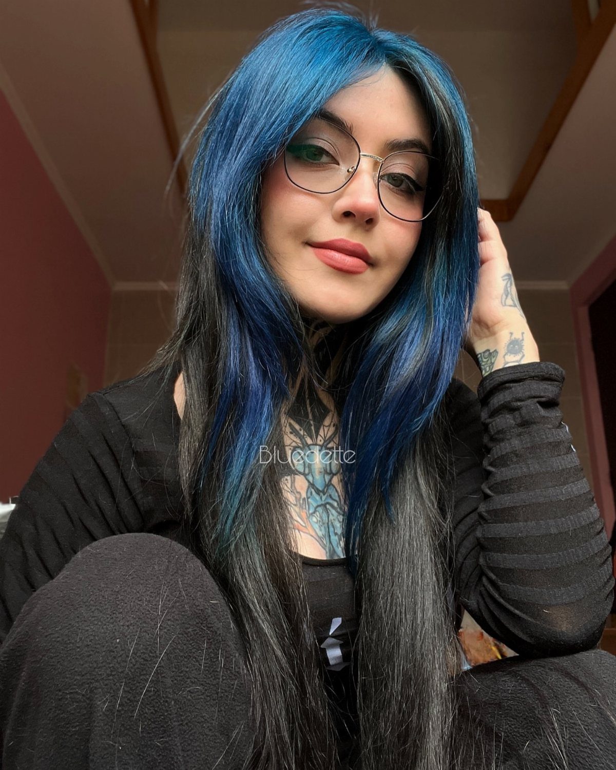 Woman with long black hair and vivid blue face-framing streaks