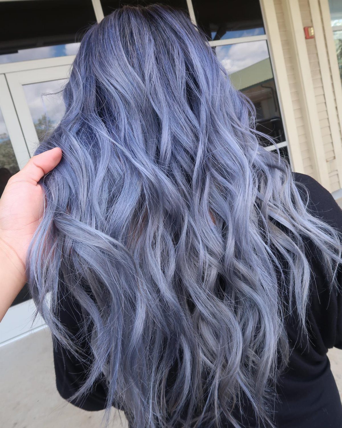 Long silver-blue waves shown from behind, with a hand touching the hair