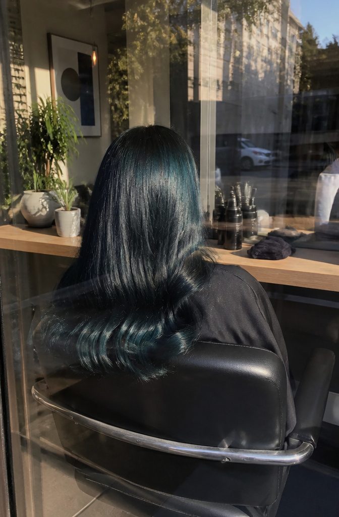 Nearly black hair with teal sheen across smooth lengths
