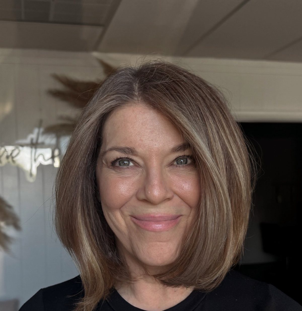 Woman with a chin-length bob blending grey strands into brown hair