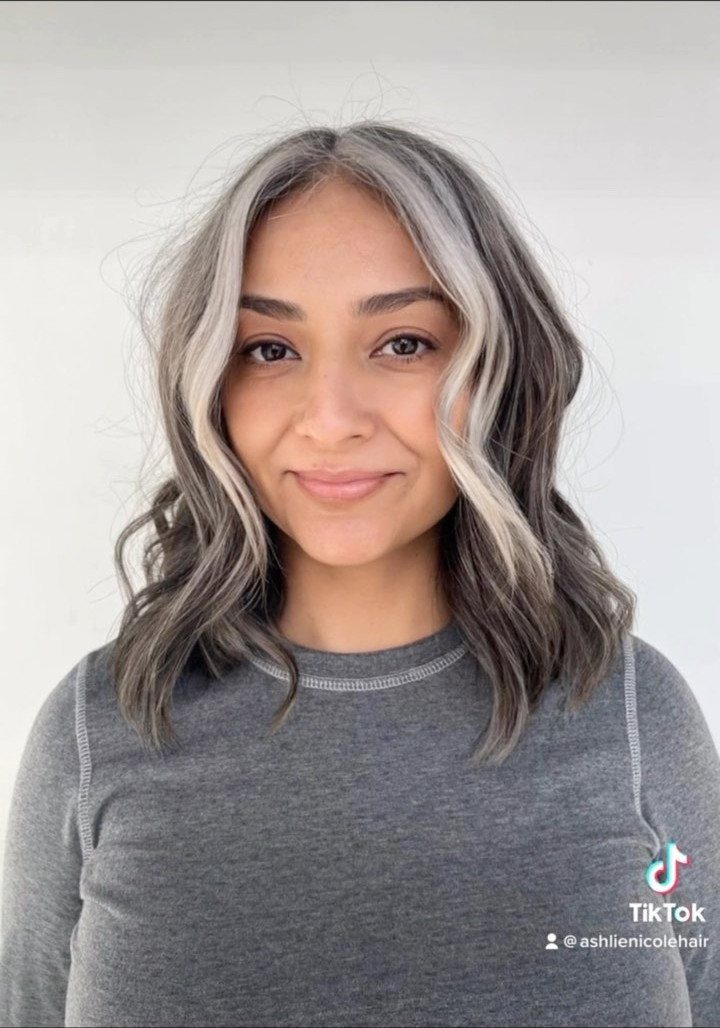 Woman with wavy gray hair and cool-blonde highlights framing her face