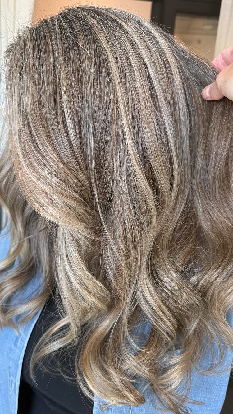 Wavy gray and beige-brown hair with blended roots and soft highlights