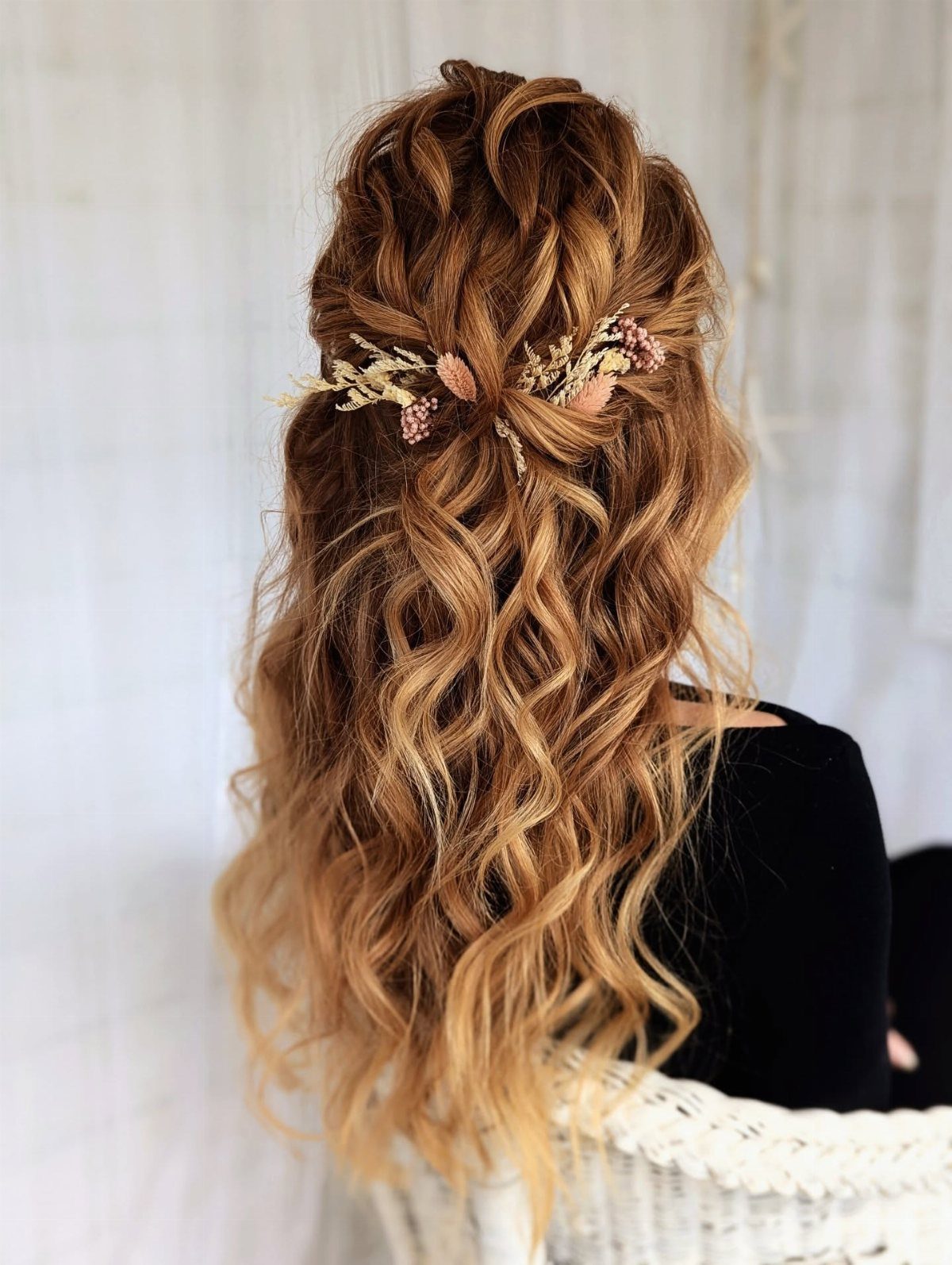 Half-up blonde waves secured with a delicate floral clip