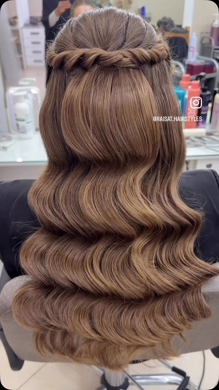 Braided headband crosses above long, softly waved light brown hair
