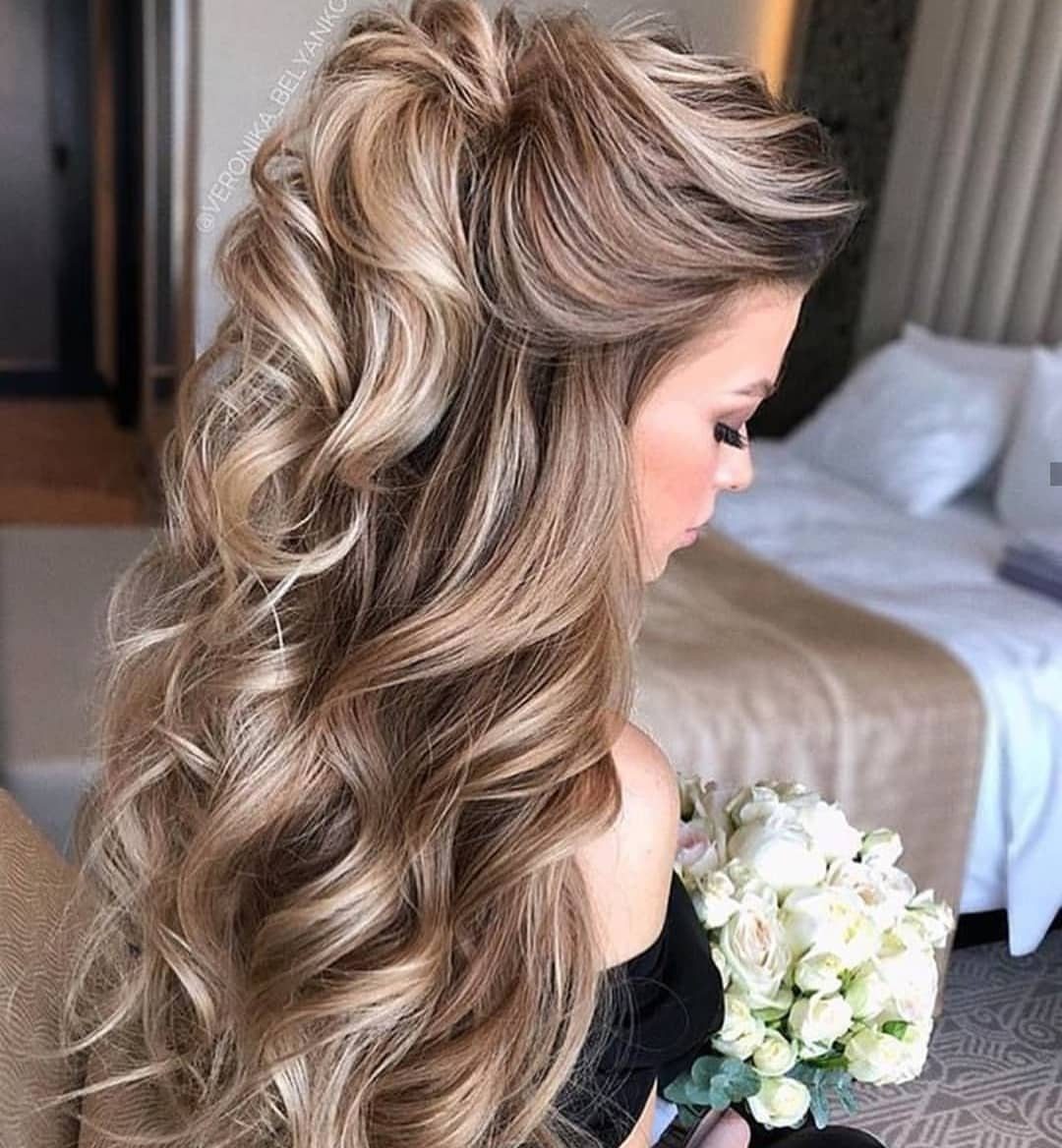 Blonde bridal hair swept into a crown bump with cascading curls