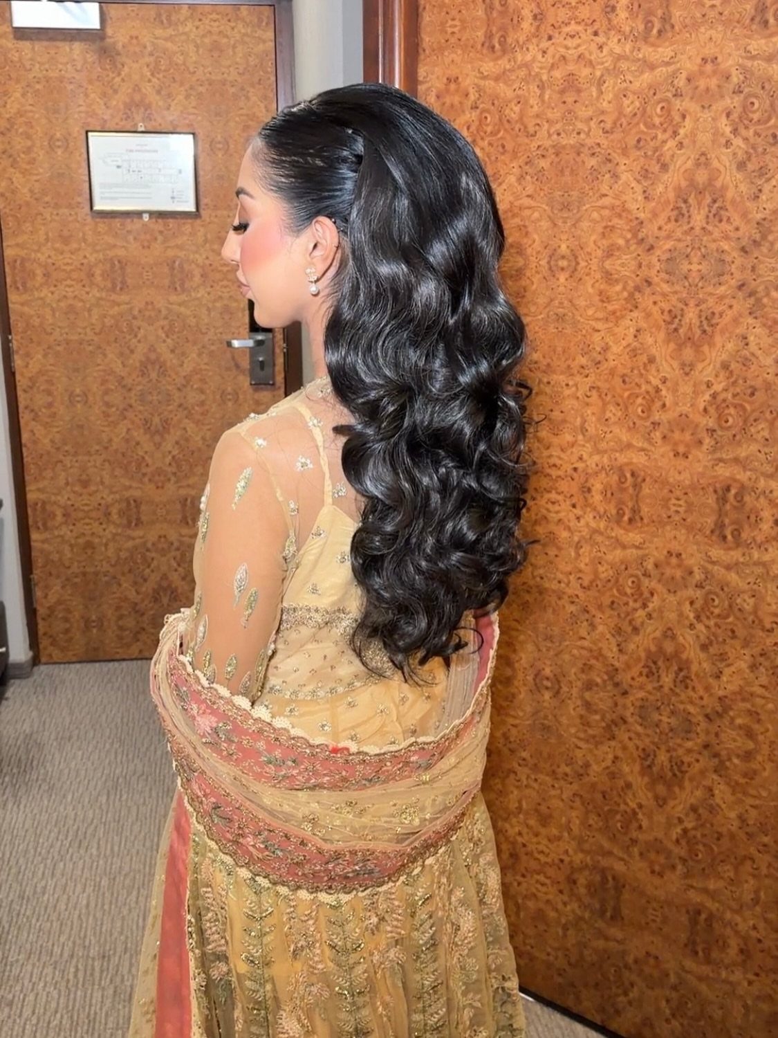 Woman with voluminous crown and cascading dark curls in embroidered attire