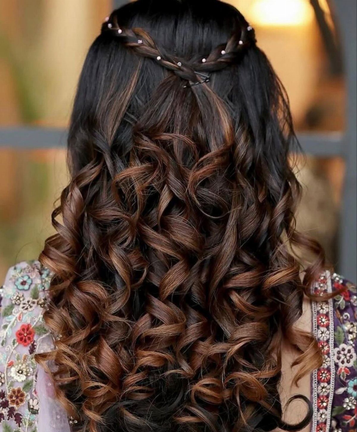 Highlighted curls fall beneath a braided crown decorated with small beads