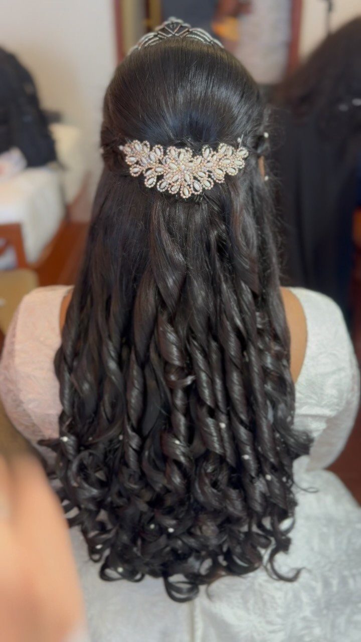 Long dark curls pinned half up with a jeweled floral hairpiece