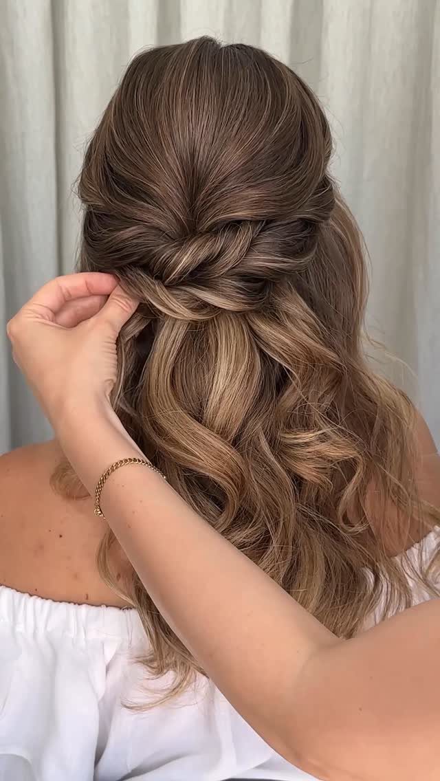 Twisted side sections woven together over long, loose brown waves
