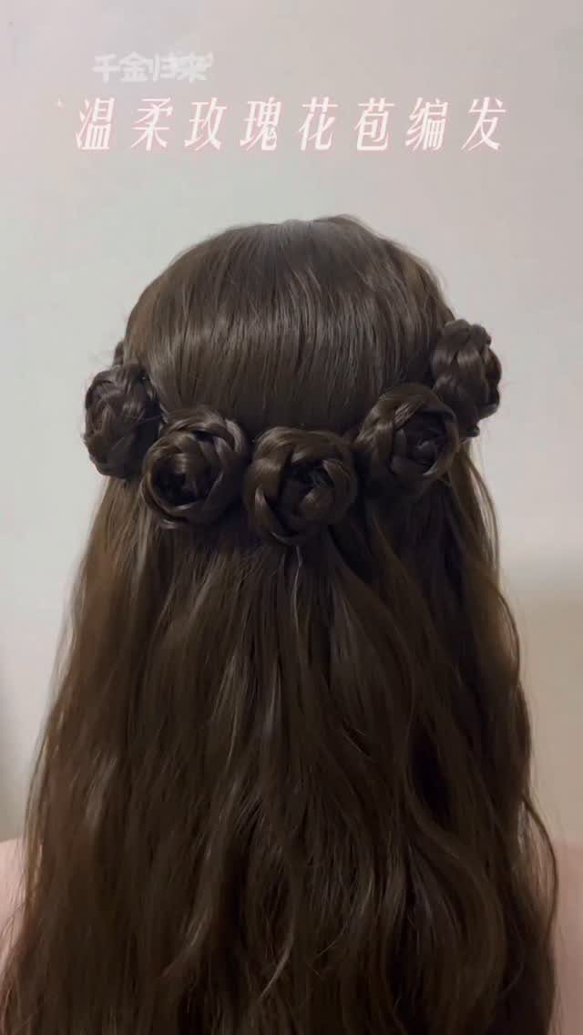 Long dark hair with three twisted rosettes pinned above loose waves