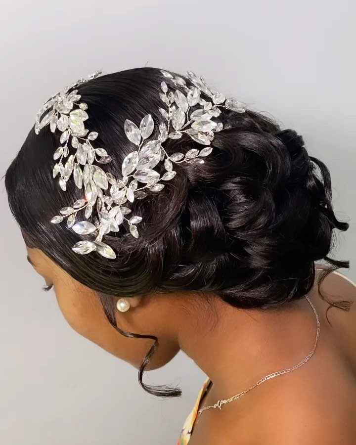 Dark sculpted waves swept into an updo with white floral hair ornaments