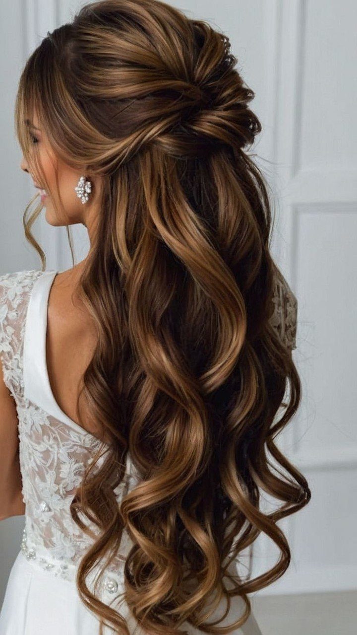 Bride wearing long brown curls in an elegant half-up wedding hairstyle