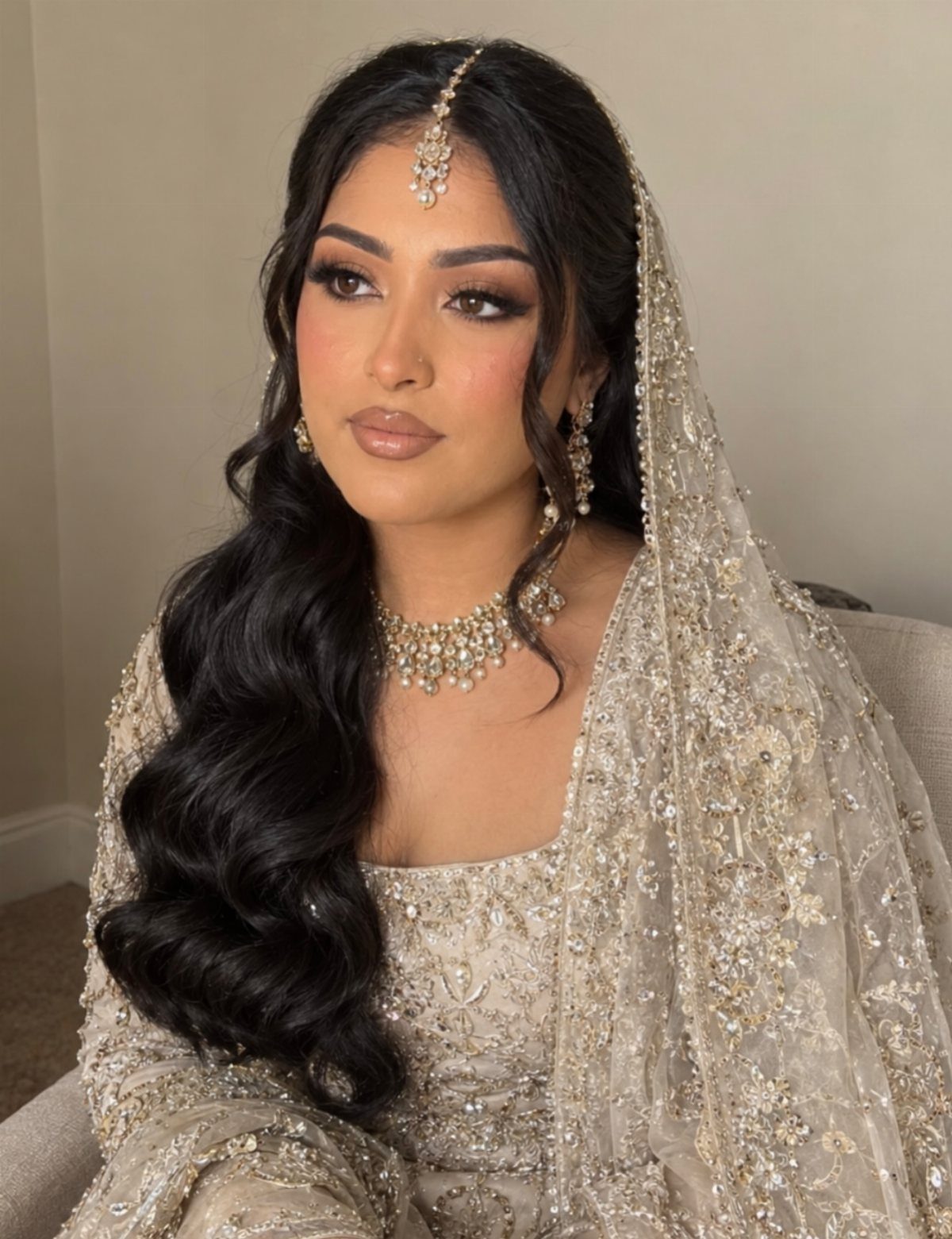 Bride with long, loose dark waves over one shoulder and jeweled veil