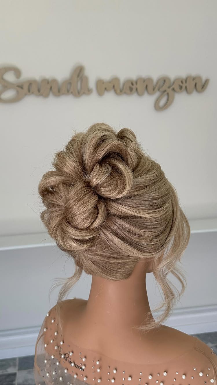 Blonde bride wearing a voluminous textured updo with loose curls and pinned sections