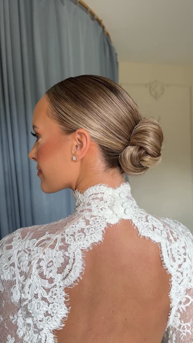Woman with a refined, smooth brown bun wearing a white lace garment