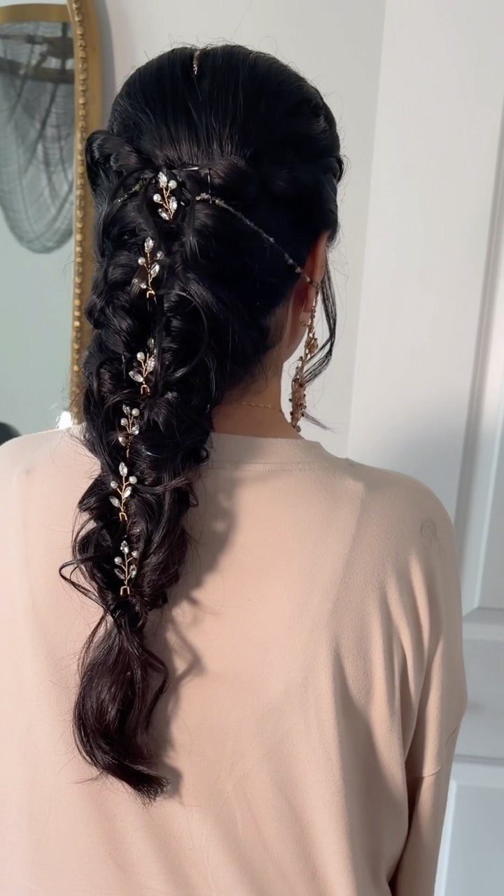 Loose decorated braid cascading down a woman's back with gold hair accents