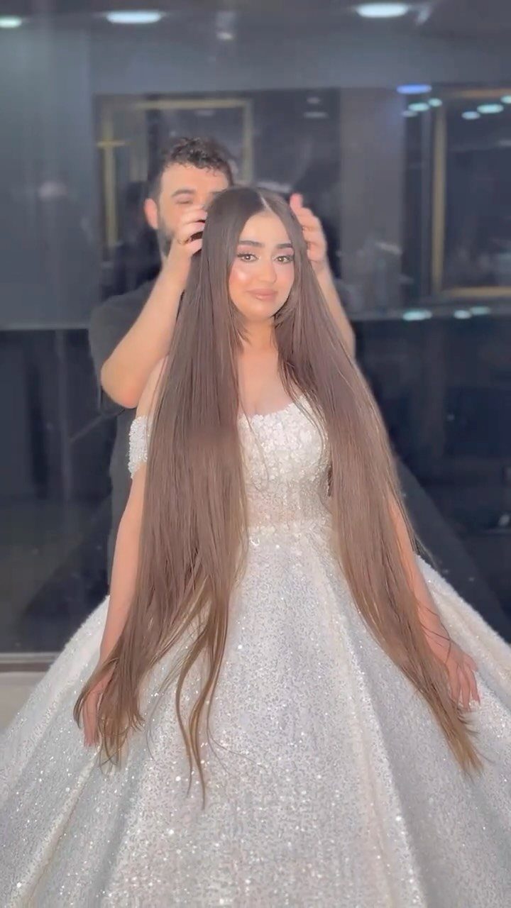 Bride with very long straight brown hair being styled in a salon