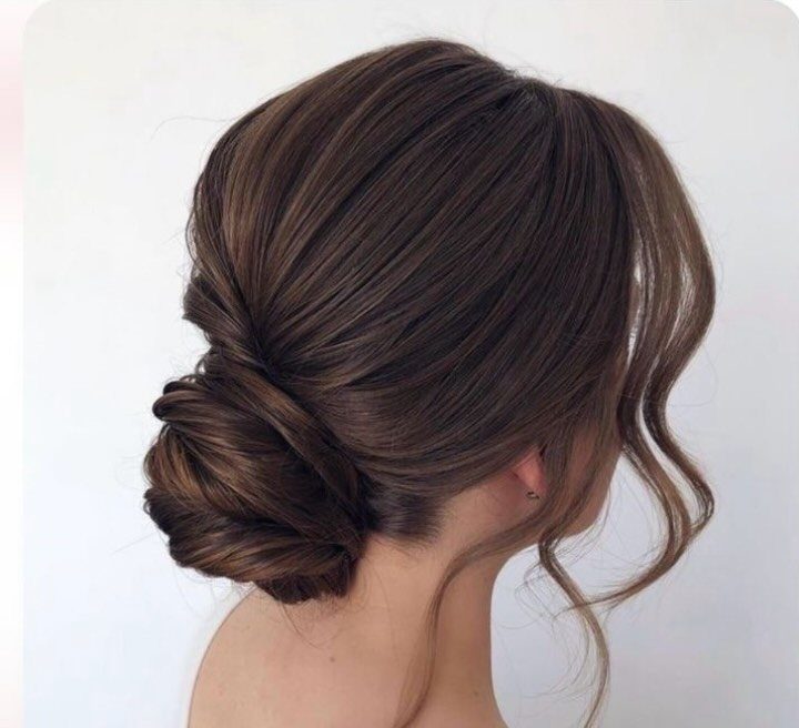 Bridal updo with twisted low bun and loose curled tendrils