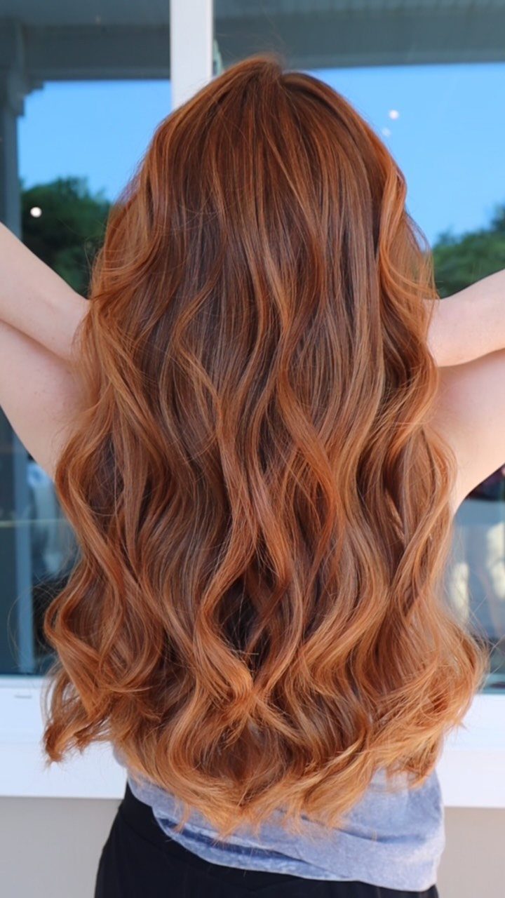Wavy copper-red hair with golden highlights viewed from behind