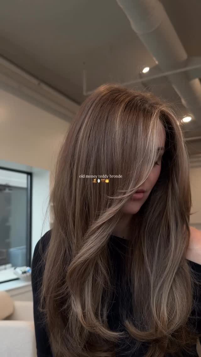 Long layered bronde hair with a sweeping fringe and sun-kissed lighter strands