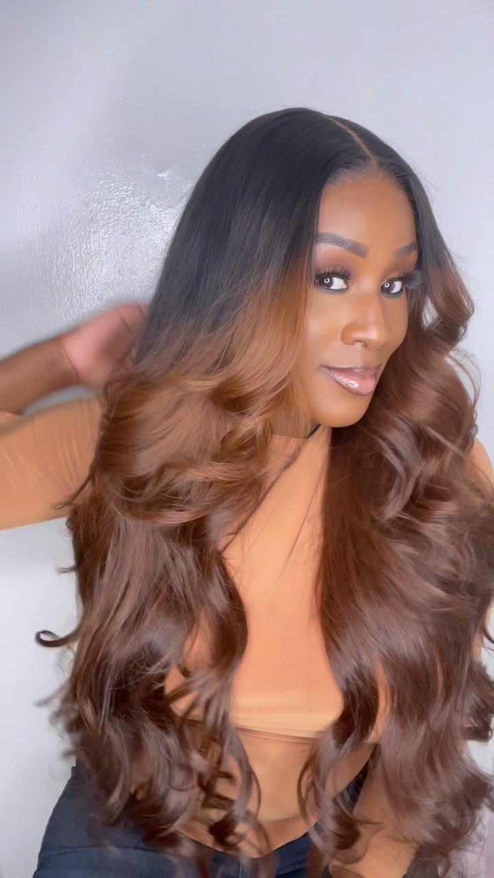 Long curled hair fades from dark brown roots to lighter brown ends