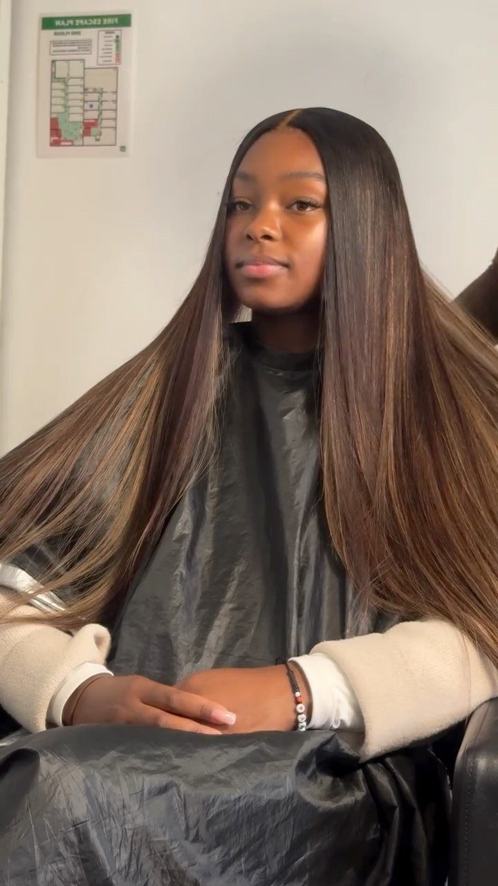 Long dark brown hair with subtle copper warmth, styled straight in a salon