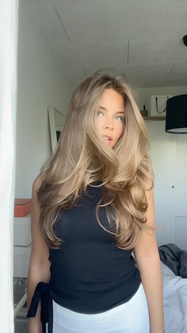 Woman with long honey-toned brown hair and soft golden highlights