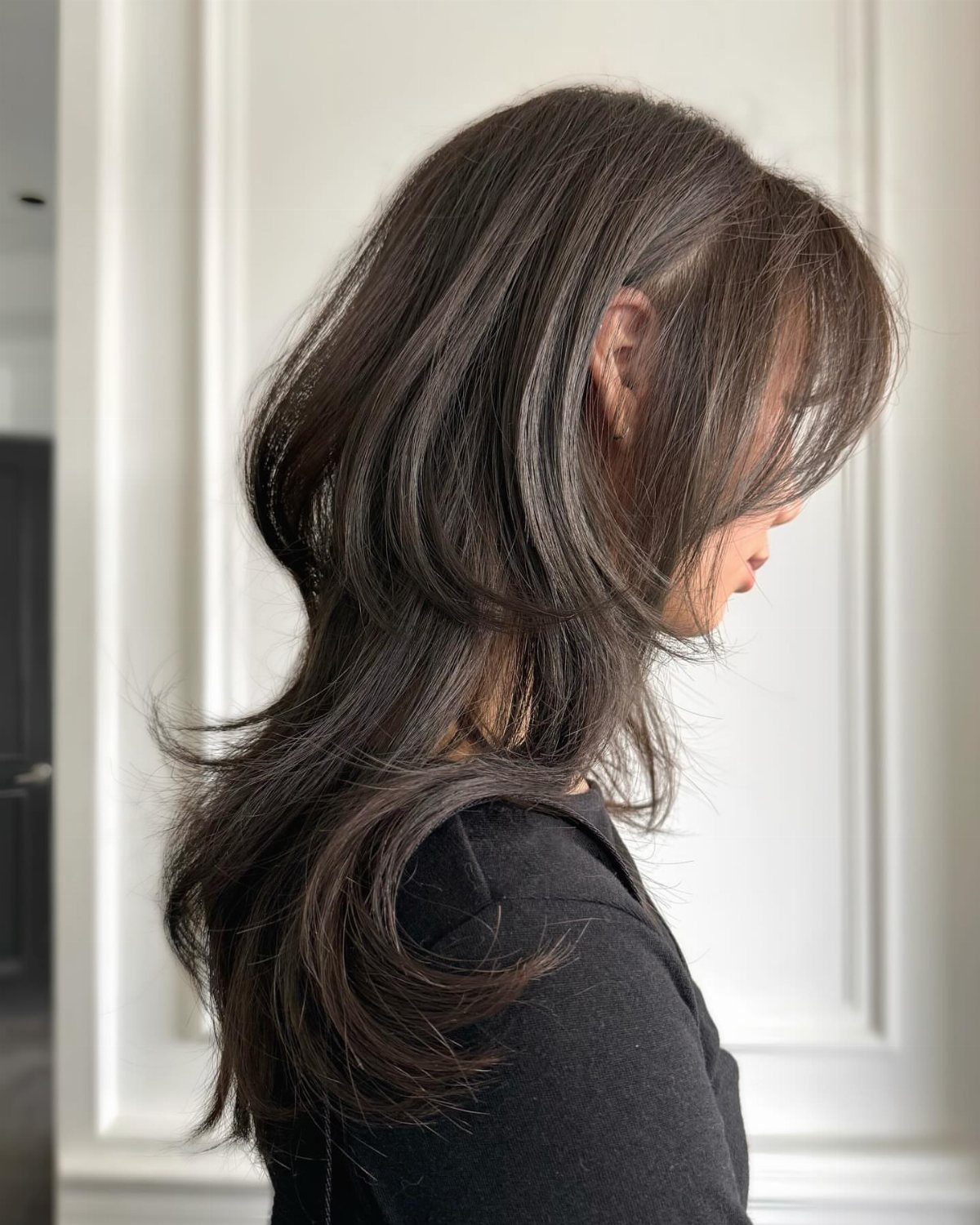 Woman with layered, cool-toned brown hair and soft fringe