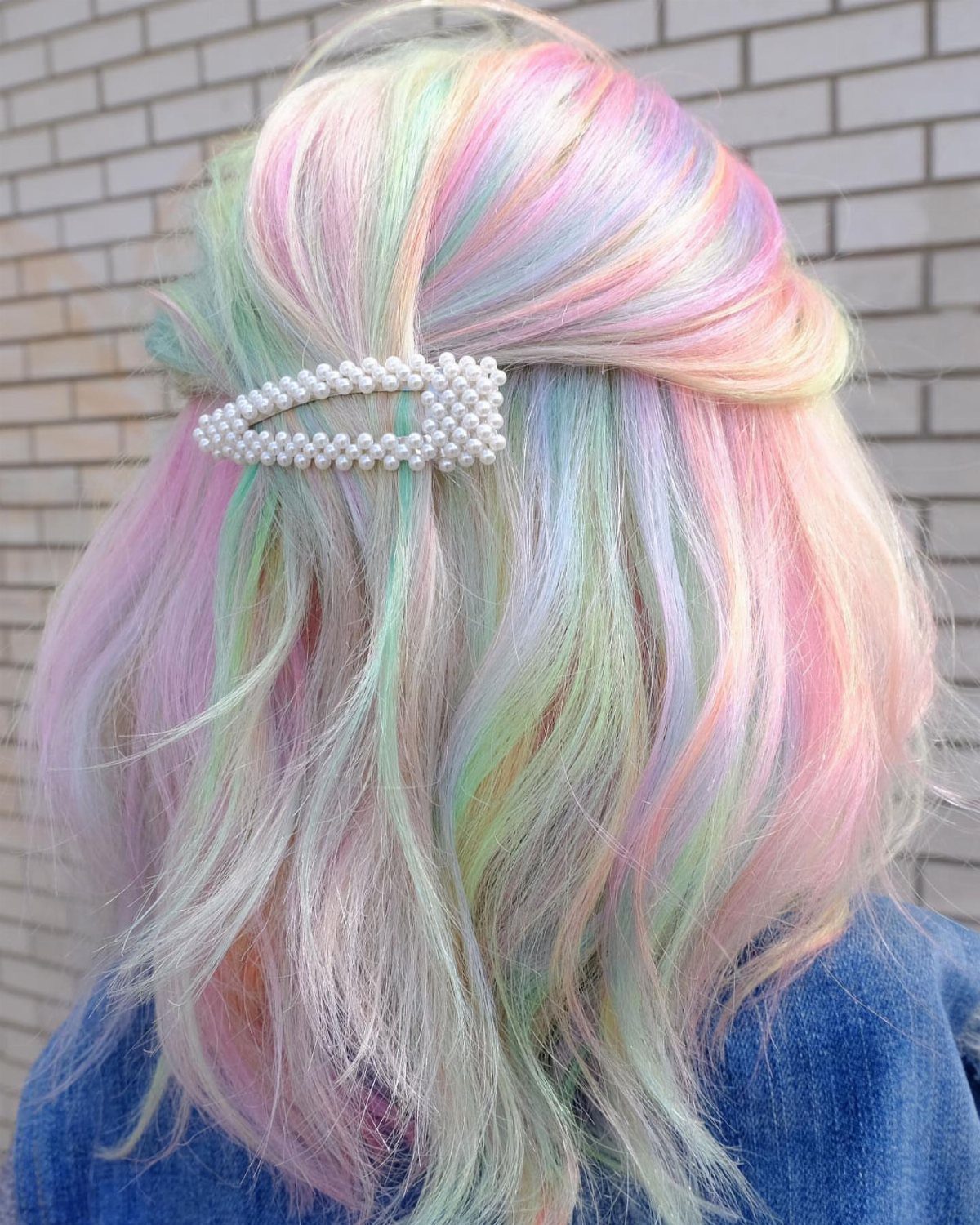 Long pastel pink, blue, green, and lavender hair held with a pearl barrette