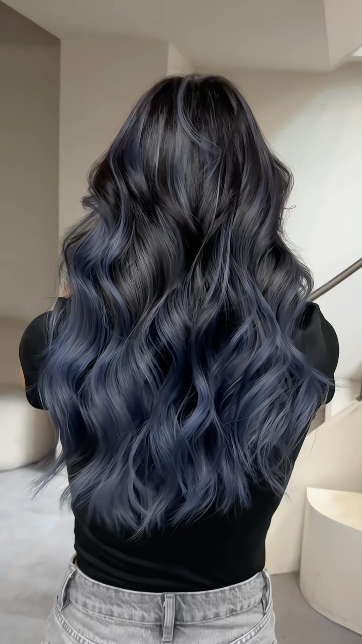Long wavy dark hair with blue balayage blended through the lengths