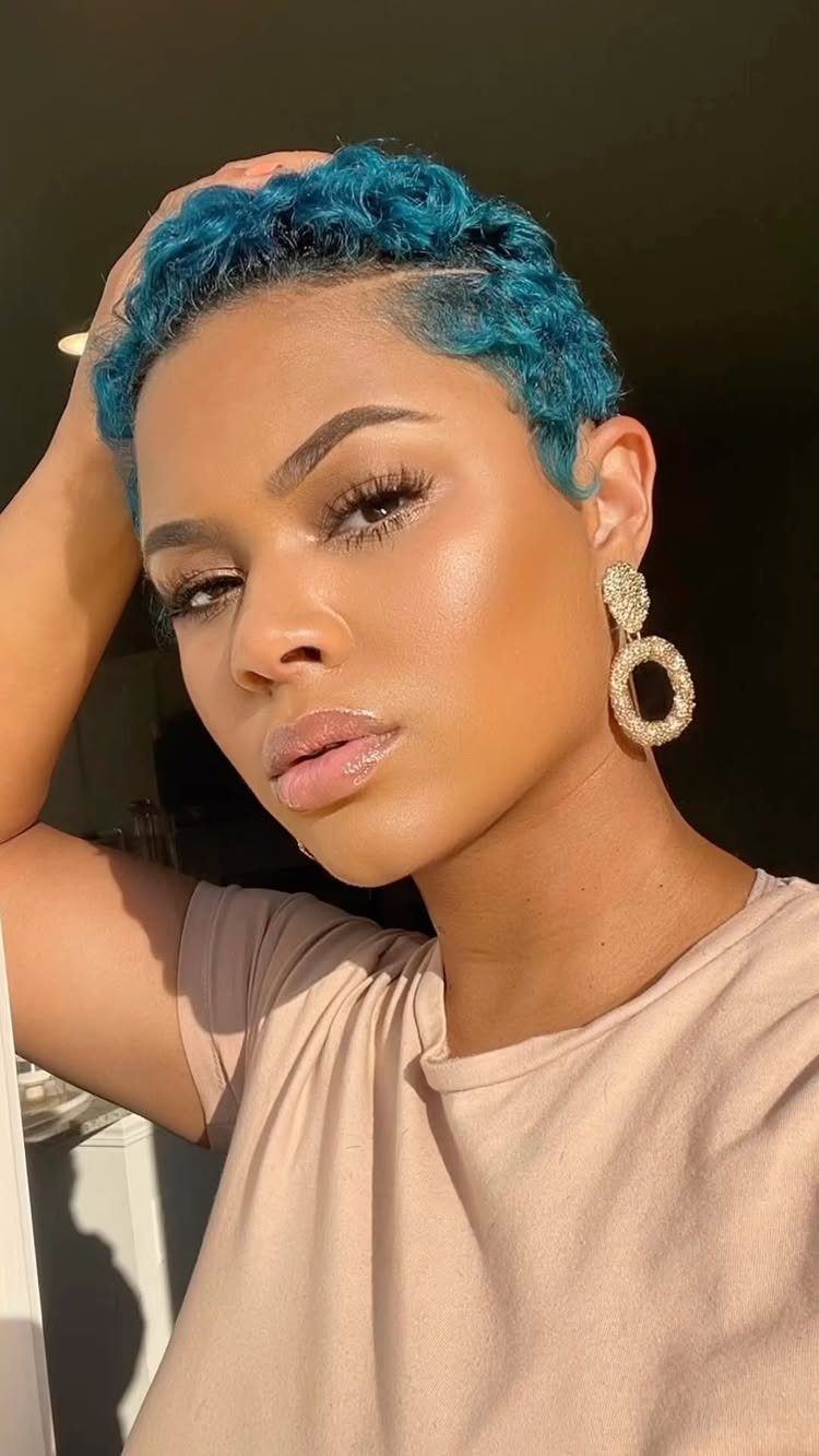 Woman posing with short, tightly curled bright blue pixie hair