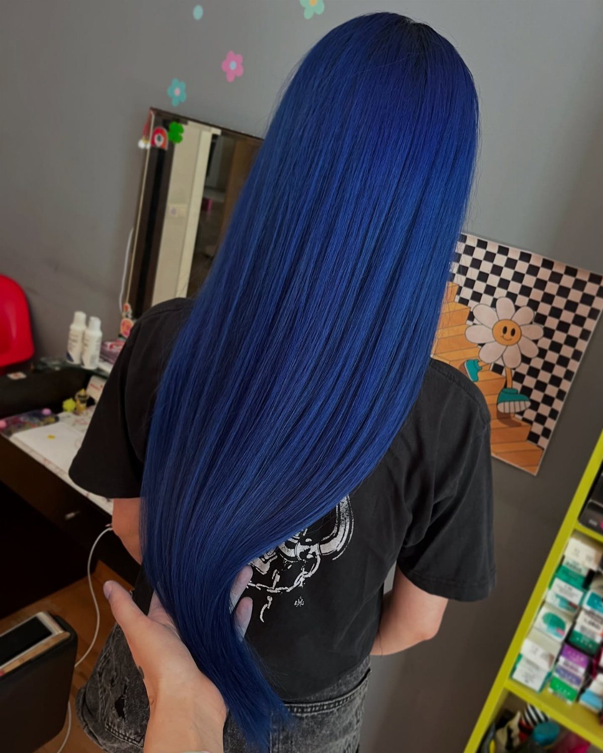 Long vivid royal-blue hair falls straight down the person's back