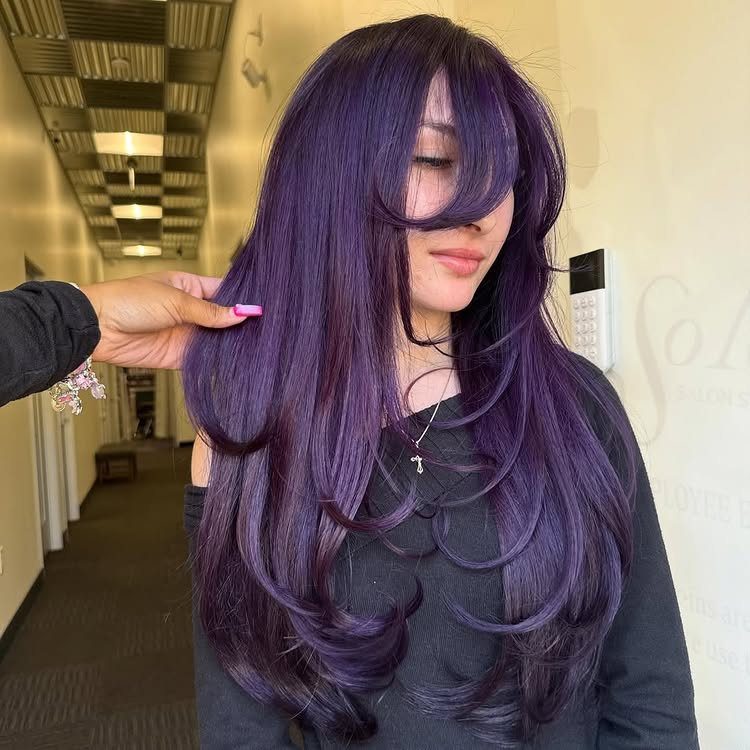 Long dark violet hair with heavy bangs and layered curled ends
