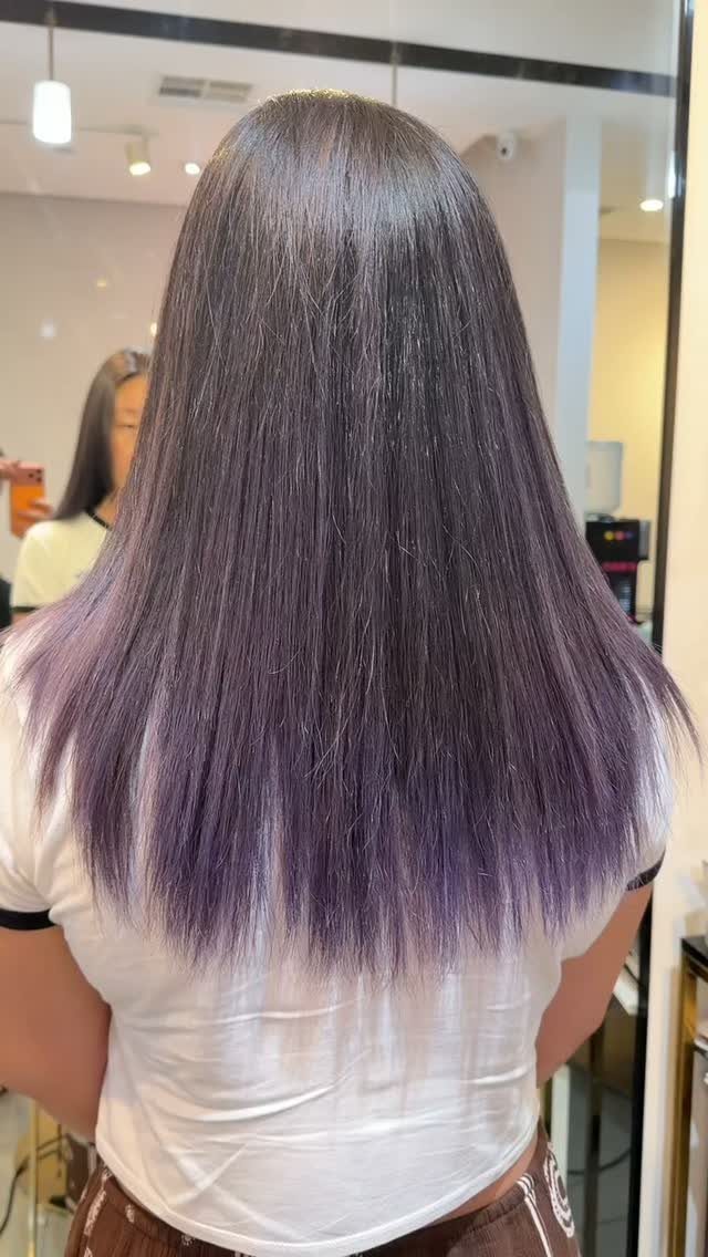 Long straight dark hair transitions into muted purple ombre ends