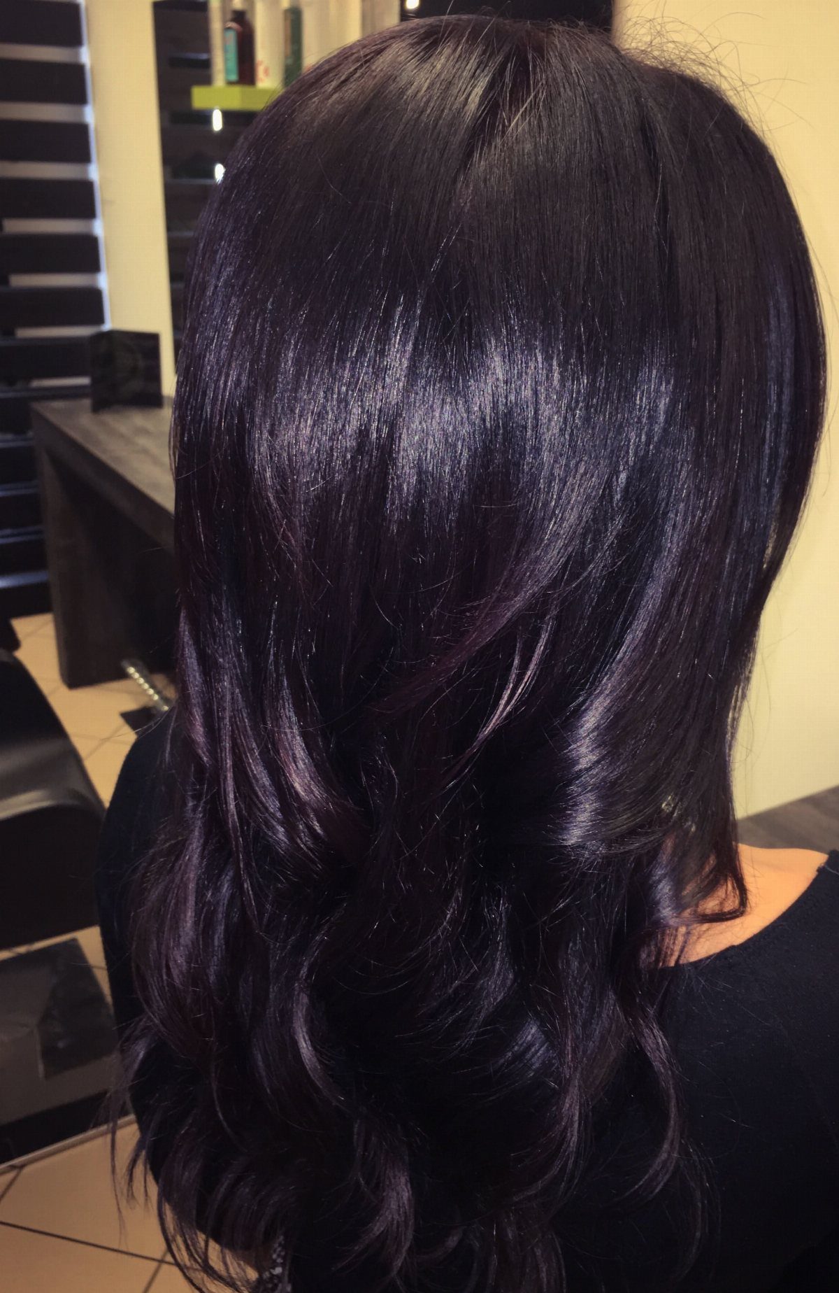 Long glossy dark hair with subtle violet-purple sheen and loose waves