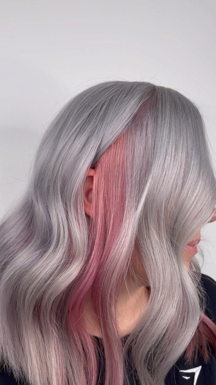 Long silver-gray waves frame a broad pink section beside the face