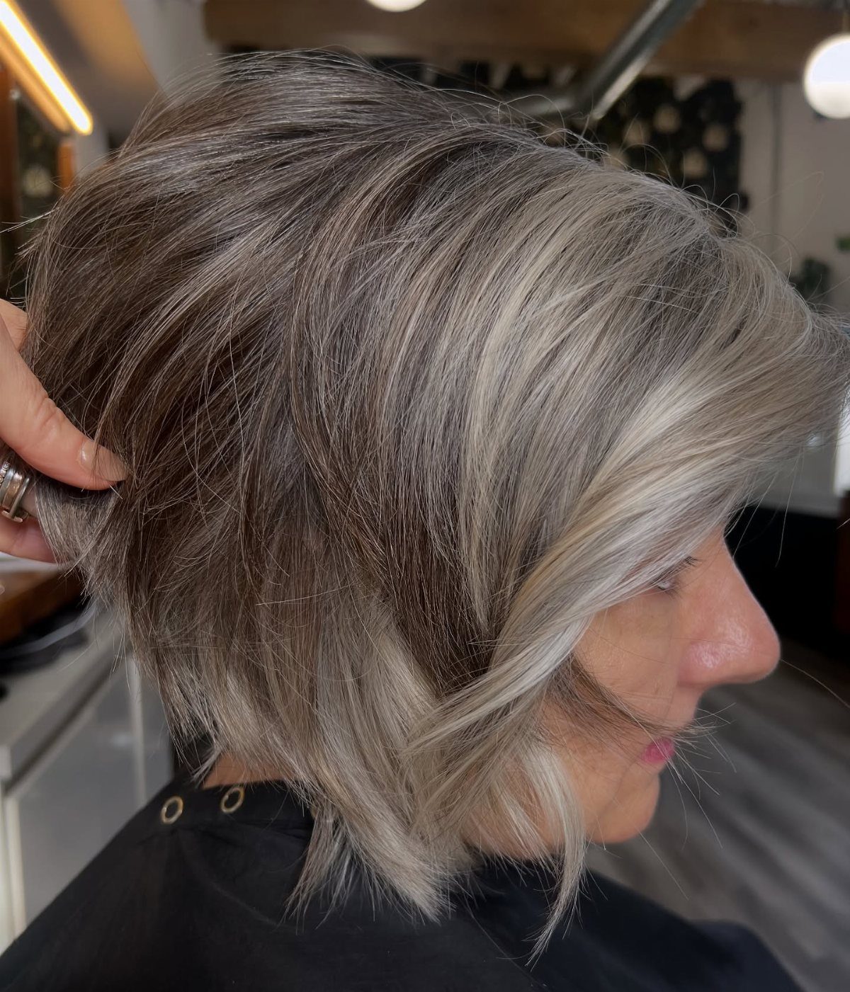 Layered bob with dark roots and blended silver-grey hair in loose waves