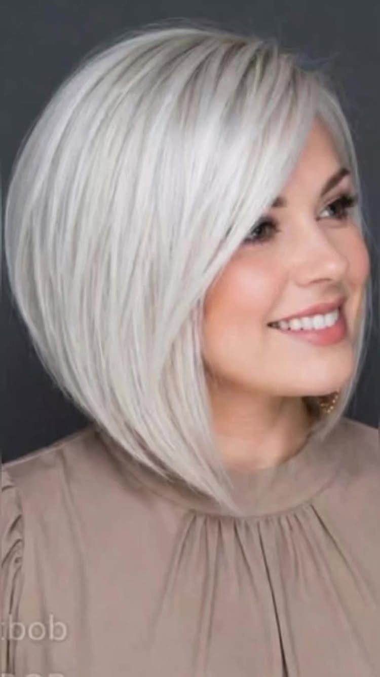 Woman wearing a rounded chin-length silver bob with side-swept bangs