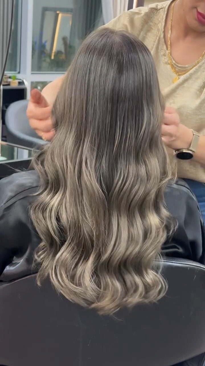 Long wavy brunette hair blends into pale ash-blonde balayage ends