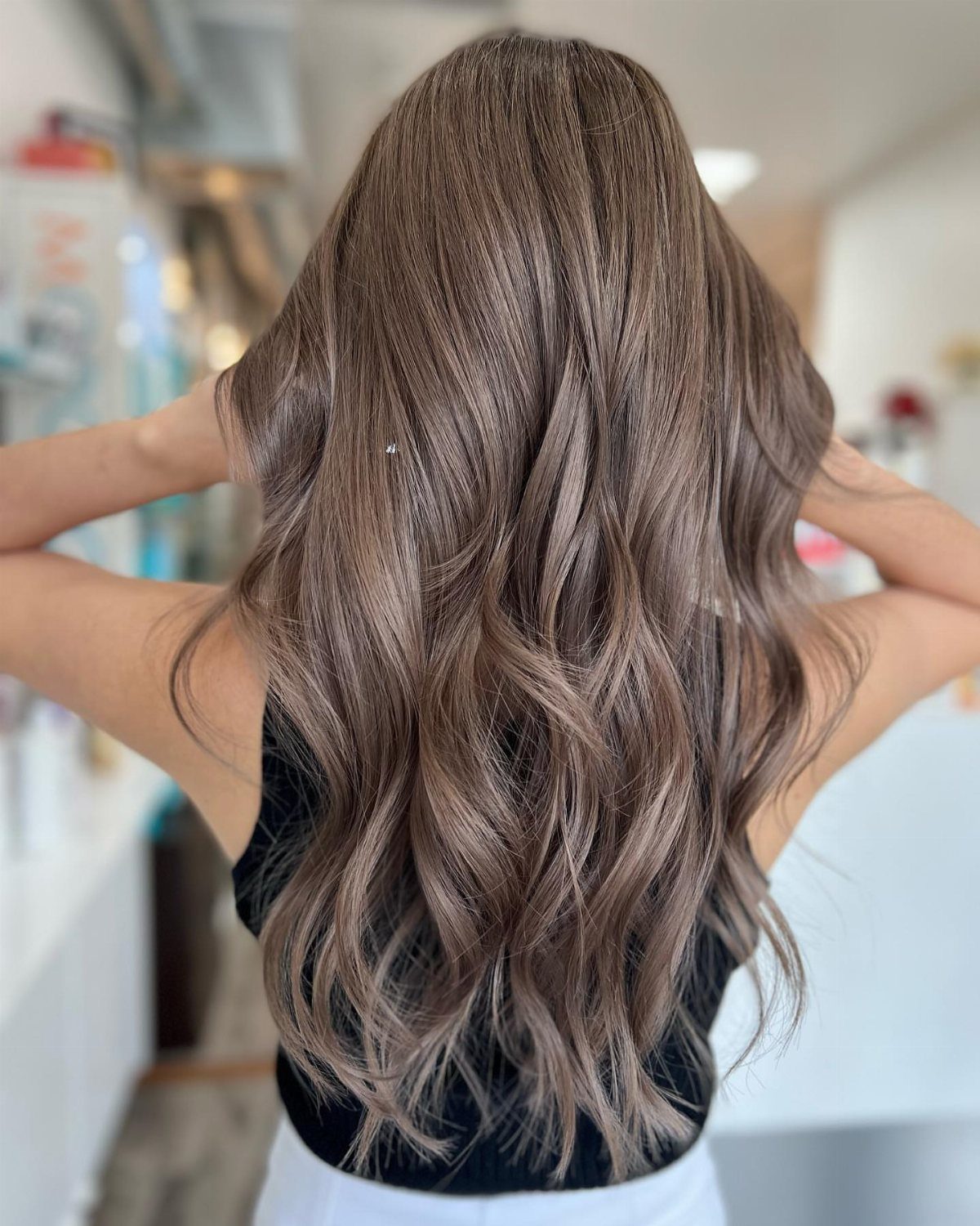 Long wavy mousy brown hair with cool pewter-gray tones shown from behind