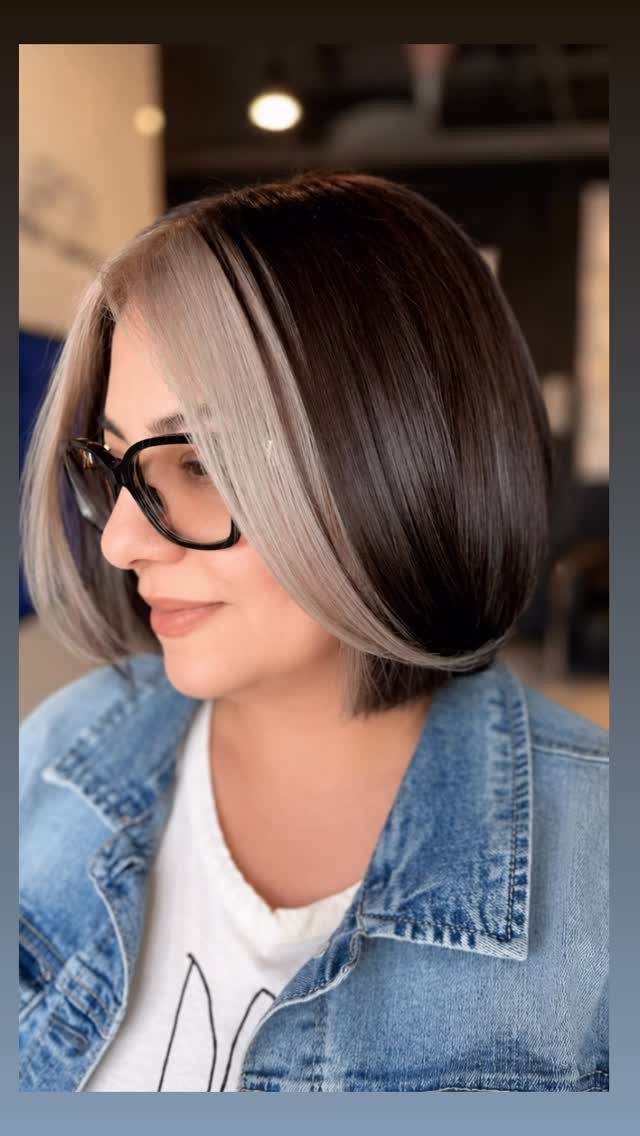 Woman with a dark bob and a broad blonde streak framing her face