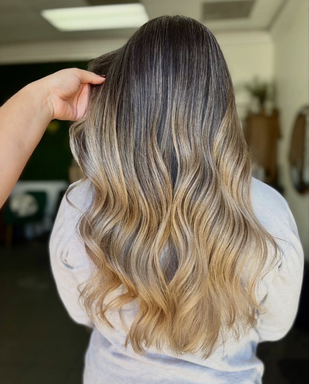 Long dark hair blends into silver-gray and blonde balayage highlights