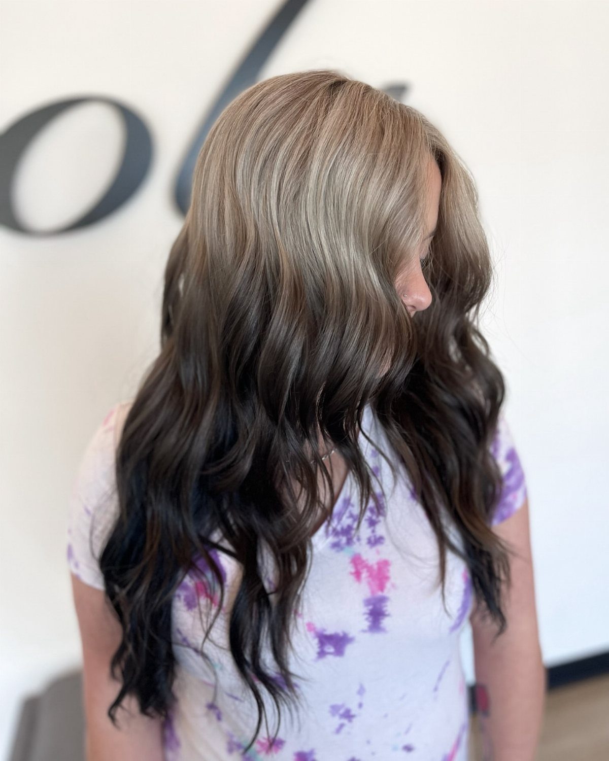 Long wavy hair fades from ash gray roots into dark ends