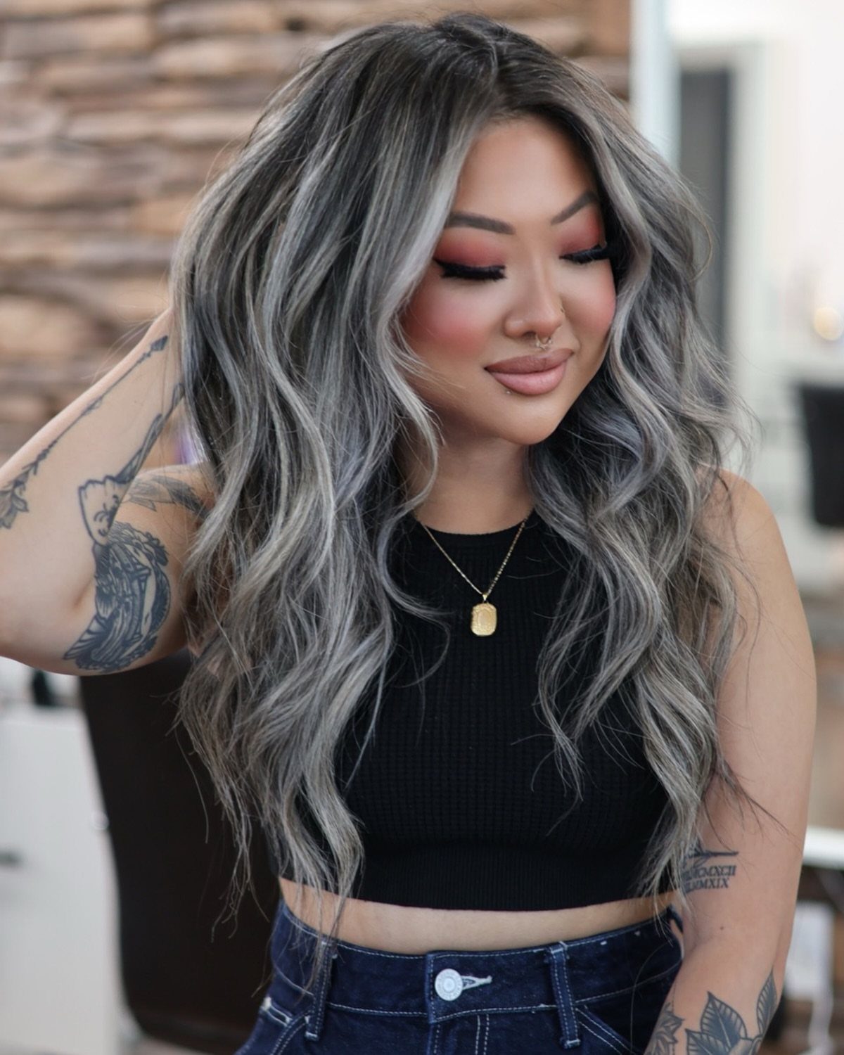 Long dark hair blends into wavy silver-gray lengths around a woman’s face