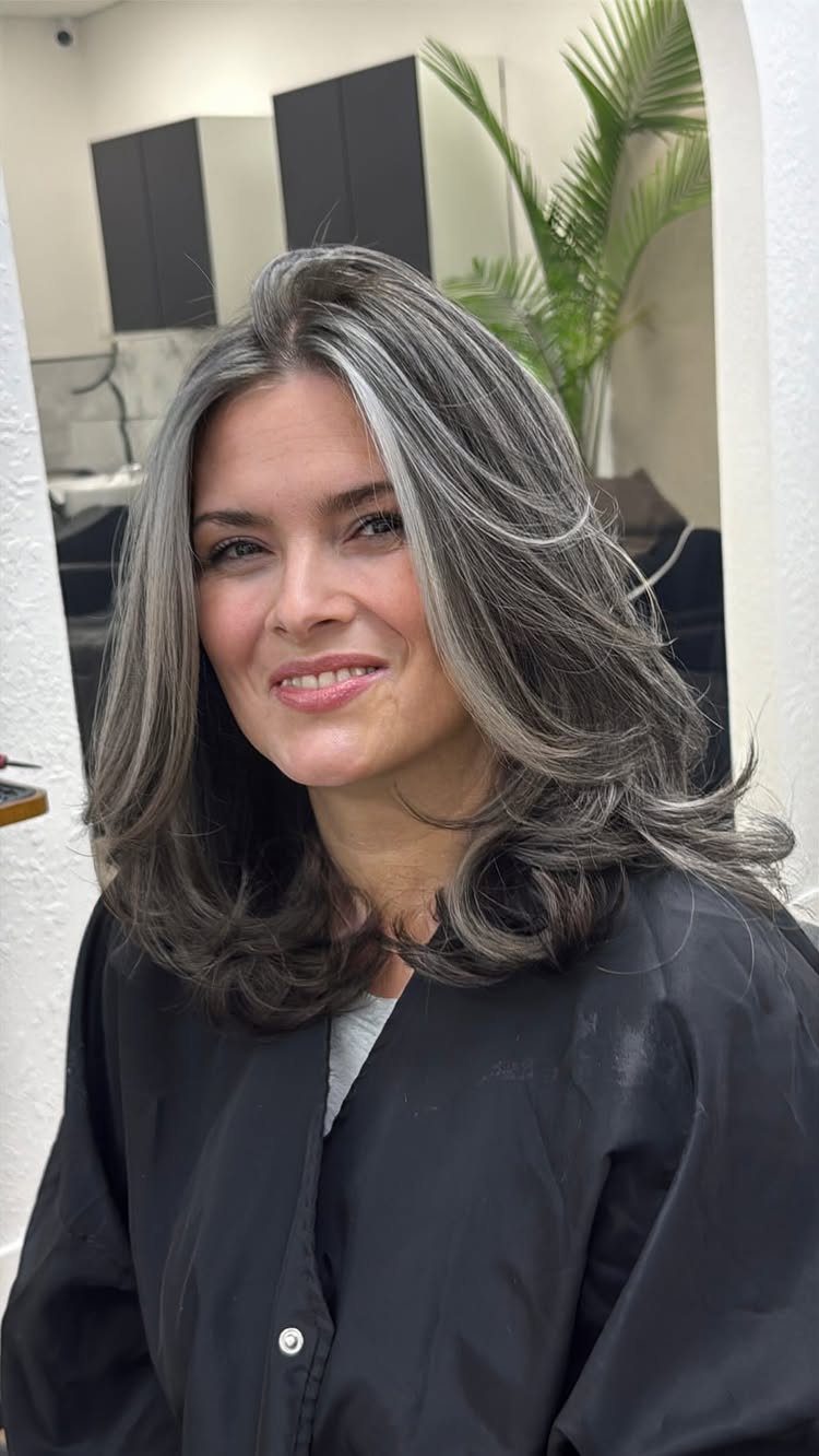 Woman showing dark hair blended with sweeping silver-gray highlights