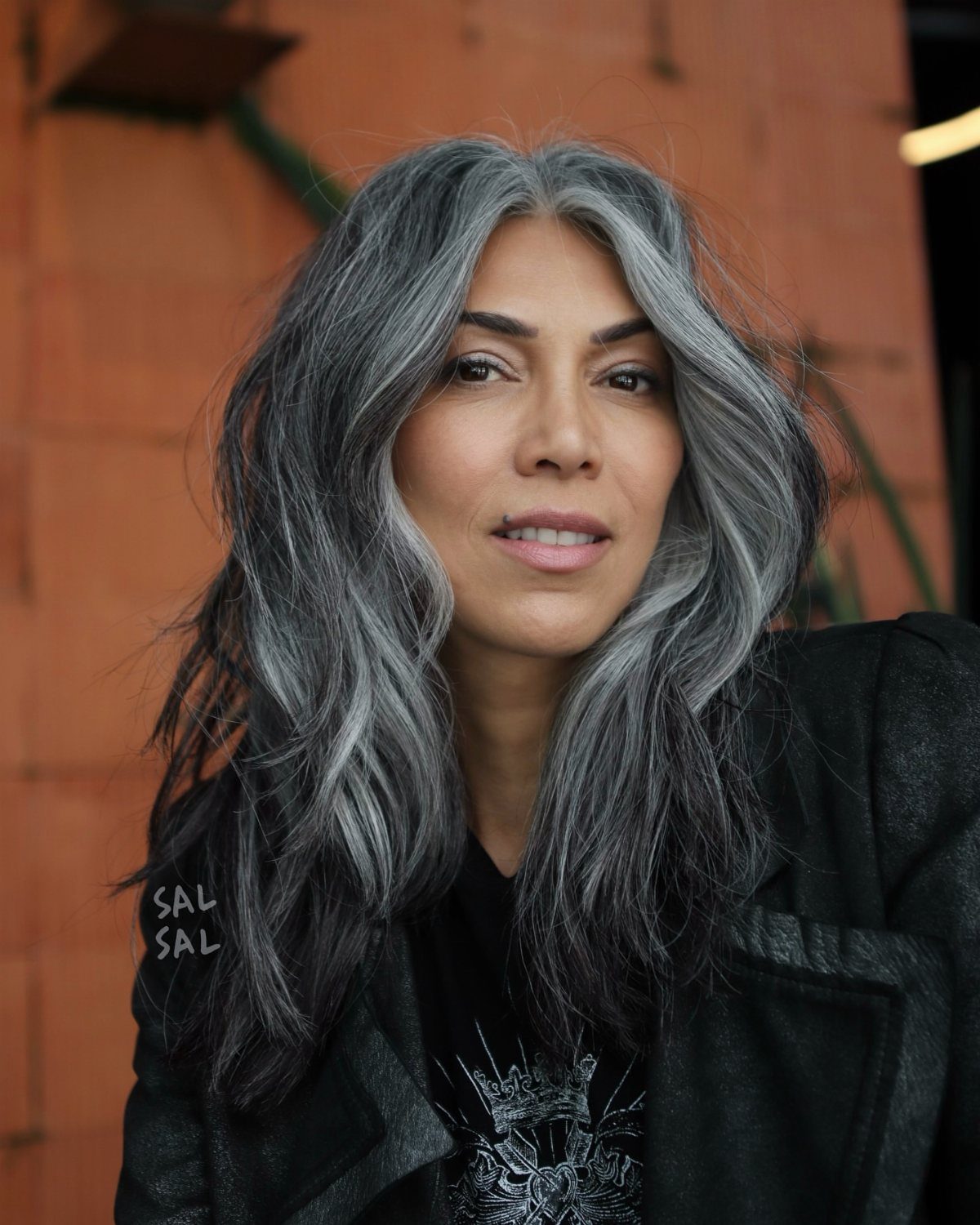 Woman wearing long, loose silver and salt-and-pepper waves