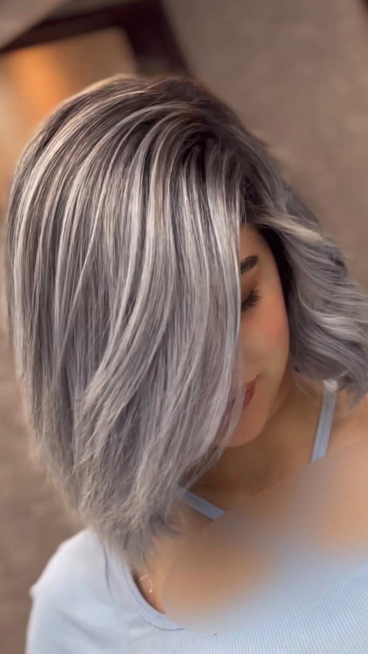 Woman wearing a wavy chin-length silver and dark grey bob