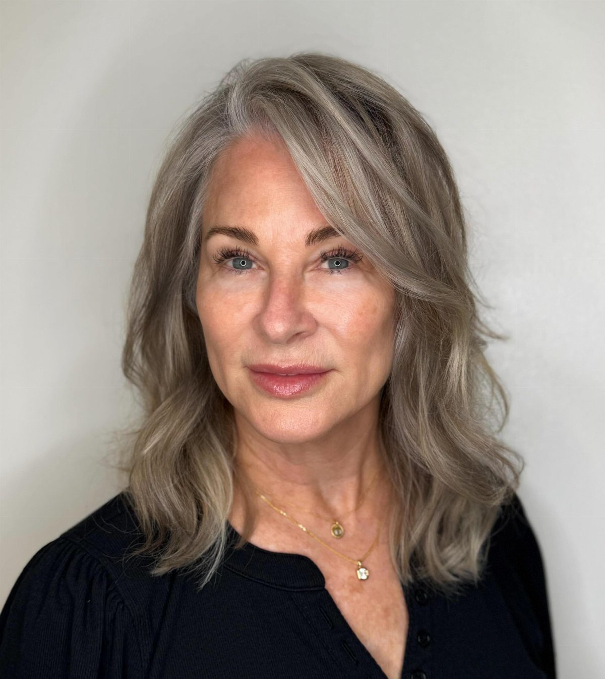 Woman with long, layered grey hair and a center part